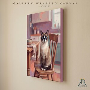 May include: A gallery wrapped canvas with a 1.5 inch depth featuring a painting of a Siamese cat with blue eyes sitting on a wooden chair in a kitchen. The scene includes a wooden table with a bowl and a cloth. The text reads GALLERY WRAPPED CANVAS.