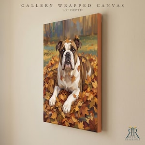 May include: A gallery wrapped canvas with a 1.5 inch depth featuring a painting of a brown and white bulldog lying in a pile of fallen autumn leaves. The artwork displays a forest background with warm orange, yellow, and brown tones.