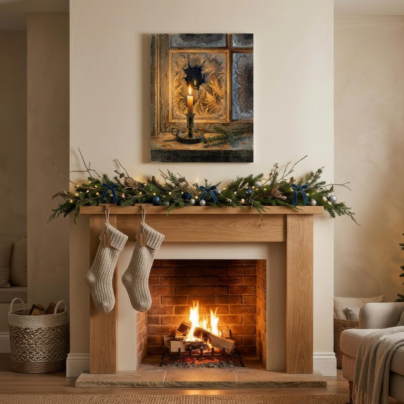 May include: A fireplace mantel featuring a green garland with blue bows and lights, two beige knit stockings, and a wall art print depicting a lit candle in a candle holder placed on a windowsill with frost patterns on the glass panes.