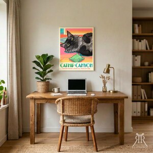 K&ouml;nnte beinhalten: Ein rechteckiges Wandposter mit einem schwarzen Katzenmotiv, die auf einem bunten Boden mit einem gr&uuml;nen Kissen liegt. Der Text lautet CATNIP CANYON und VISITORS REPORT LOSING ALL TRACE OF TIME. Das Poster h&auml;ngt an einer Wand &uuml;ber einem Holztisch.