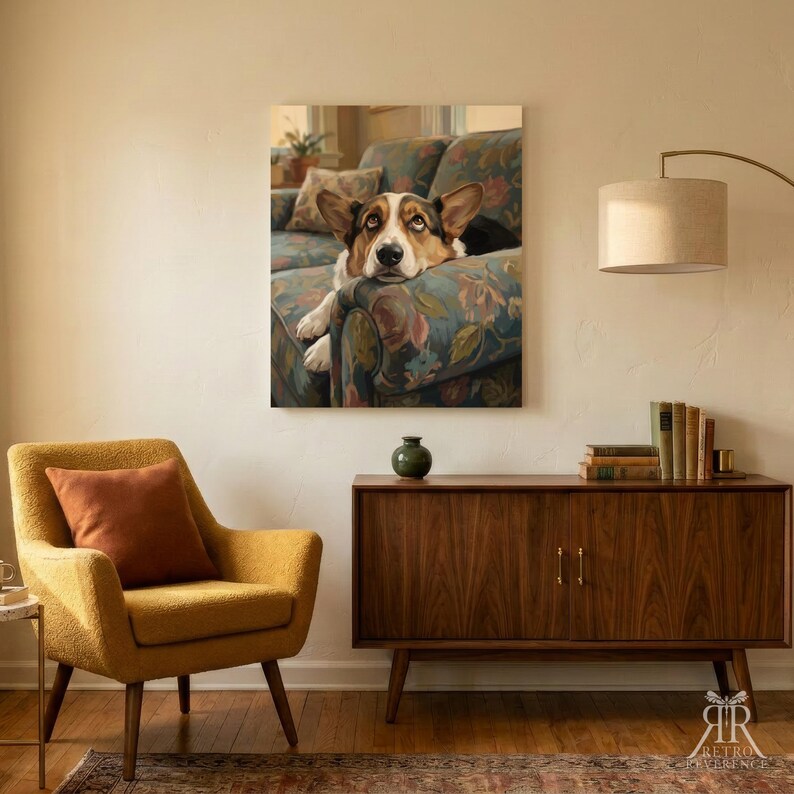 May include: A rectangular wall art print featuring a brown and white dog resting on a floral patterned sofa. The artwork is displayed on a plain wall above a wooden sideboard, a yellow armchair with a brown pillow, and a floor lamp.
