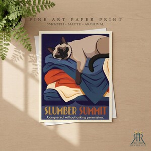 May include: A fine art paper print featuring a Siamese cat sleeping on a stack of folded blankets in shades of blue, orange, and cream. The text reads SLUMBER SUMMIT and Conquered without asking permission. The print has a smooth matte finish.