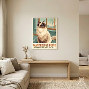 May include: A rectangular wall art print featuring a fluffy cream and brown cat sitting by a window. The text WANDERLUST POINT and DREAMING BIG. STAYING PUT. is printed in bold letters at the bottom of the illustration in a vintage poster style.