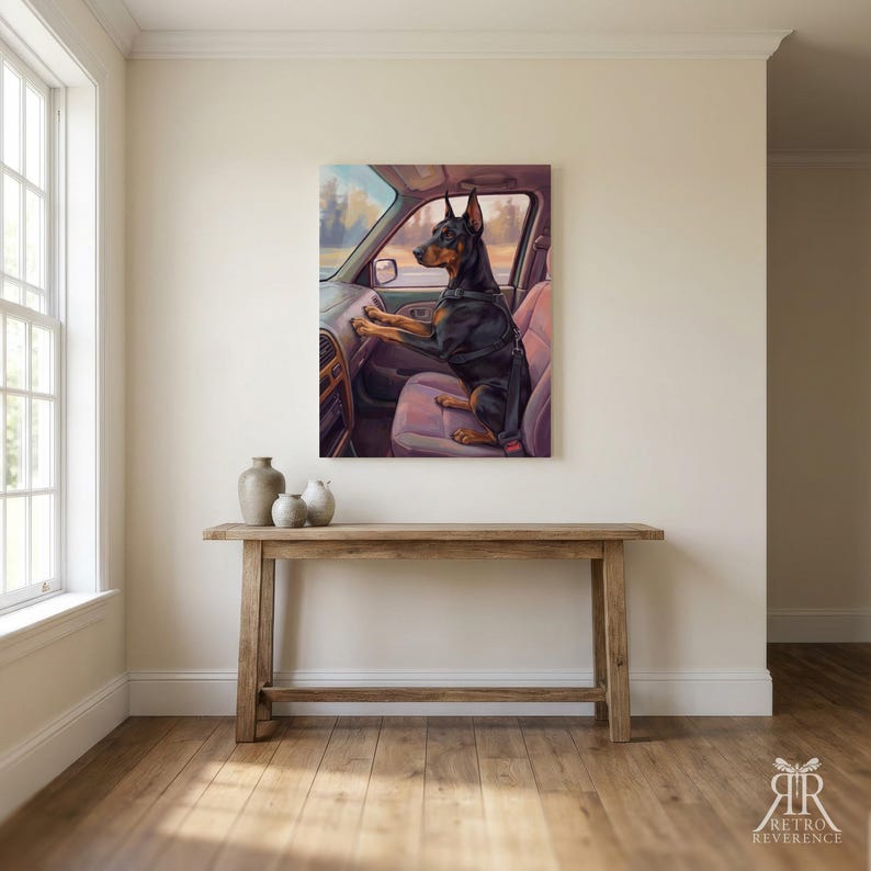 May include: A rectangular wall art print depicting a black and tan Doberman Pinscher sitting in the passenger seat of a car. The dog is wearing a black harness and is positioned with its front paws resting on the dashboard of the vehicle.