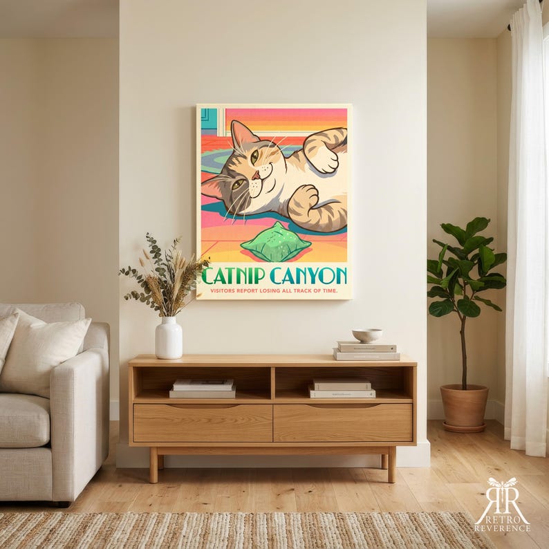 K&ouml;nnte beinhalten: Ein rechteckiger Wandkunstdruck mit einer Cartoon-getigerten Katze, die auf dem R&uuml;cken liegt und mit einem gr&uuml;nen Spielzeug spielt. Der Text lautet CATNIP CANYON und VISITORS REPORT LOSING ALL TRACK OF TIME. Der Hintergrund ist eine stilisierte Landschaft.