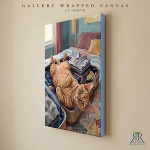 Puede incluir: Un lienzo envuelto en galer&iacute;a con una profundidad de 3,8 cm que muestra una pintura de un gato atigrado naranja acostado boca arriba dentro de una maleta abierta llena de ropa doblada. El gato tiene ojos verdes y mira al espectador.