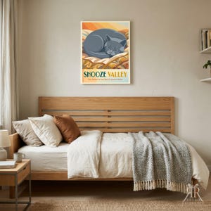 May include: A rectangular wall art print featuring a grey cat curled up asleep on a textured surface. The text reads SNOOZE VALLEY and THE CENTER OF THE BED IS ALWAYS TAKEN in dark blue and orange tones against a warm, layered background.