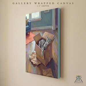 May include: A gallery wrapped canvas with a 1.5 inch depth featuring a painting of a grey tabby cat sitting inside a brown cardboard box on a wooden floor. The scene includes a blue chair and an orange rug in the background, rendered in a painterly style.
