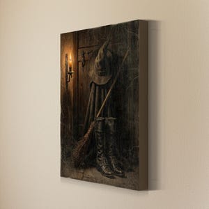 May include: A rectangular canvas wall art print depicting a dark wooden door with a pointed hat, a long cloak, a wooden broomstick, and a pair of black leather boots. A lit candle in a wall sconce illuminates the scene with warm, golden light.