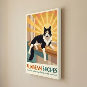 May include: A rectangular wall art print featuring a black and white cat resting on a ledge in front of a yellow sunburst. The text reads SUNBEAM SHORES, Warm rays. Endless naps. Perfect weather year-round. The design uses orange and teal tones.