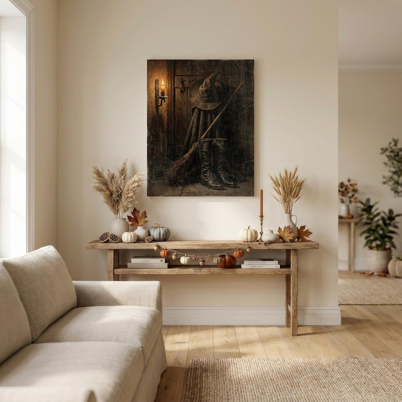 May include: A rectangular wall art print depicting a dark wooden door with a witch hat, a broomstick, and black boots leaning against it, illuminated by a wall-mounted candle. The scene features deep brown and black tones with a warm light source.