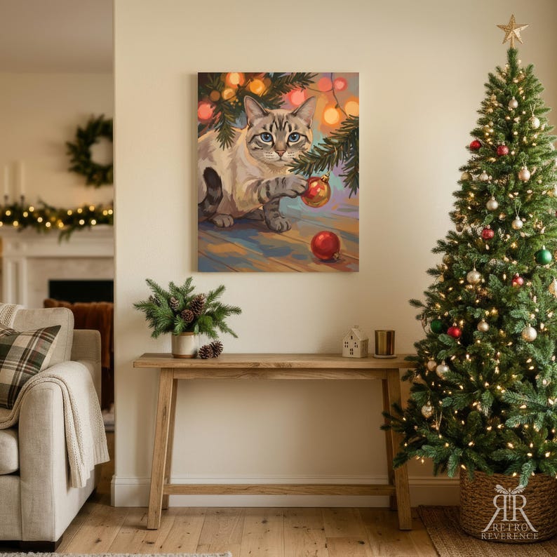 May include: A rectangular wall art print featuring a light-colored tabby cat with blue eyes reaching for a red Christmas ornament hanging from a pine branch, surrounded by warm glowing fairy lights against a soft, colorful background.