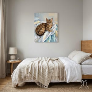 May include: A rectangular wall art print featuring a brown and black spotted Bengal cat resting on white and blue rumpled fabric. The cat has green eyes and is looking forward. The artwork is displayed in a bedroom setting above a bed.