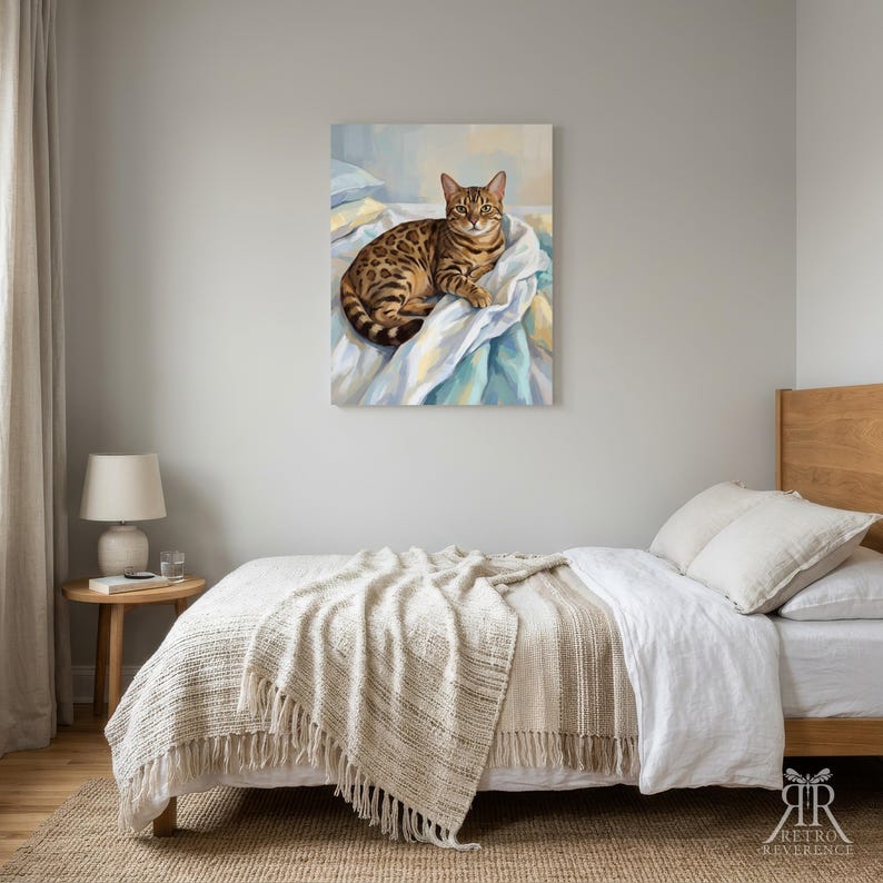 May include: A rectangular wall art print featuring a brown and black spotted Bengal cat resting on white and blue rumpled fabric. The cat has green eyes and is looking forward. The artwork is displayed in a bedroom setting above a bed.