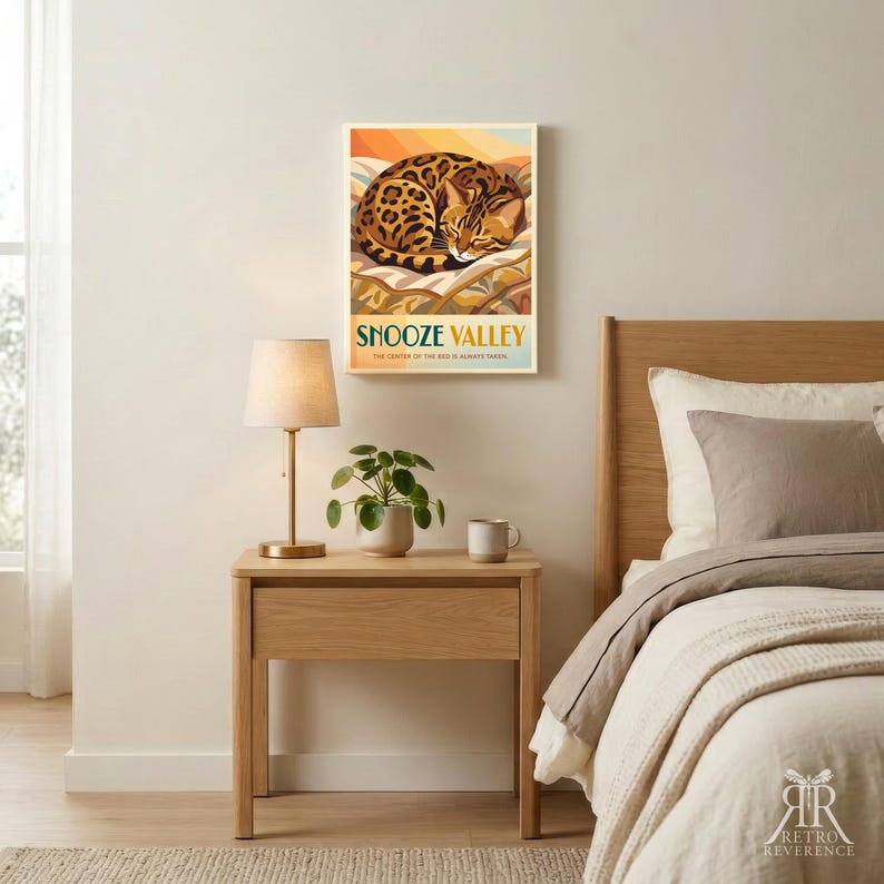 May include: A rectangular wall art print featuring a sleeping leopard curled up on a patterned surface. The text reads SNOOZE VALLEY and THE CENTER OF THE BED IS ALWAYS TAKEN. The colour palette includes shades of orange, brown, and cream.