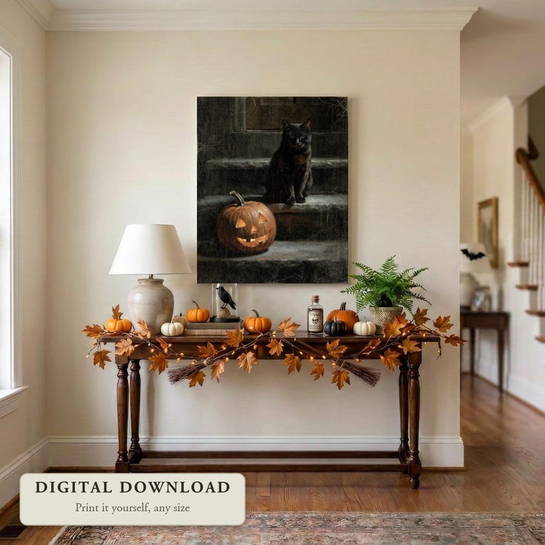 Moody vintage style Halloween art of a black cat and a jack o lantern, hung on a wall in an entryway decorated for Halloween, shown as a digital file you print yourself