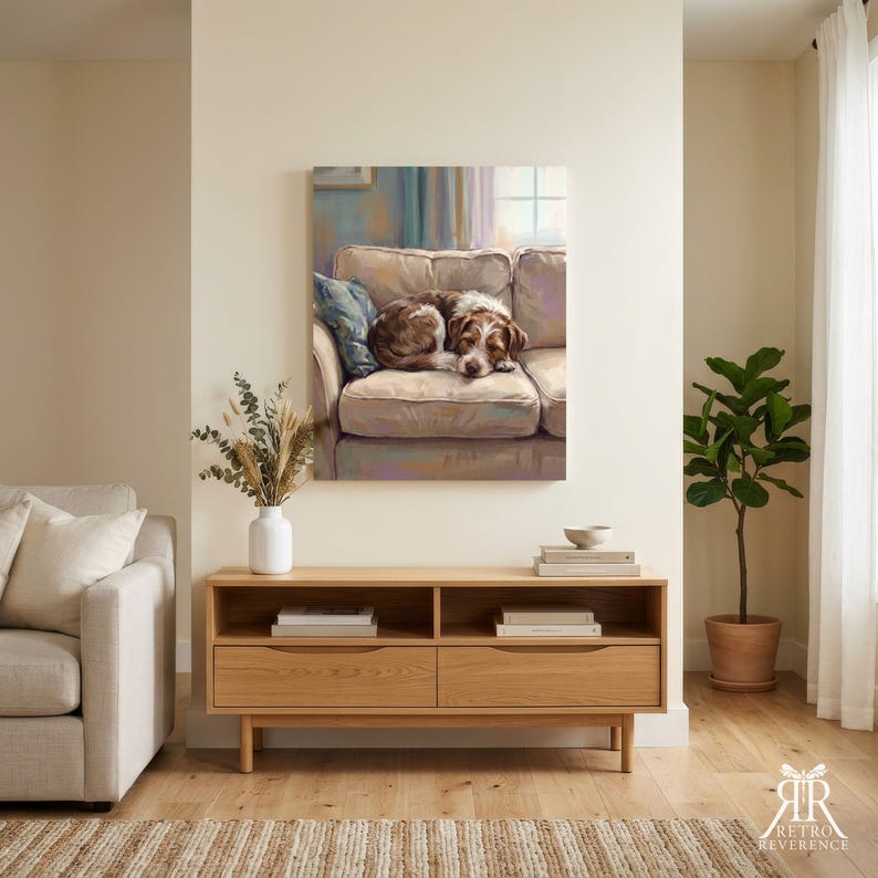 May include: A rectangular wall art print depicting a brown and white dog curled up on a beige sofa. The artwork features soft, painterly brushstrokes in muted tones of blue, purple, and cream, capturing a cozy indoor scene with a window in the background.