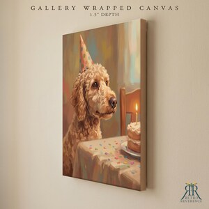 May include: A gallery wrapped canvas with a 1.5 inch depth featuring a painting of a golden-brown curly-haired dog wearing a colorful polka-dot party hat. The dog sits at a table with a birthday cake topped with a single lit candle.