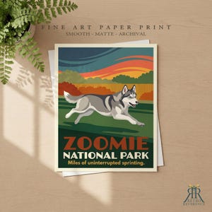 May include: A rectangular art print featuring a gray and white husky running across a green field. The background shows orange and blue sunset skies. Text reads: FINE ART PAPER PRINT, ZOOMIE NATIONAL PARK, Miles of uninterrupted sprinting.