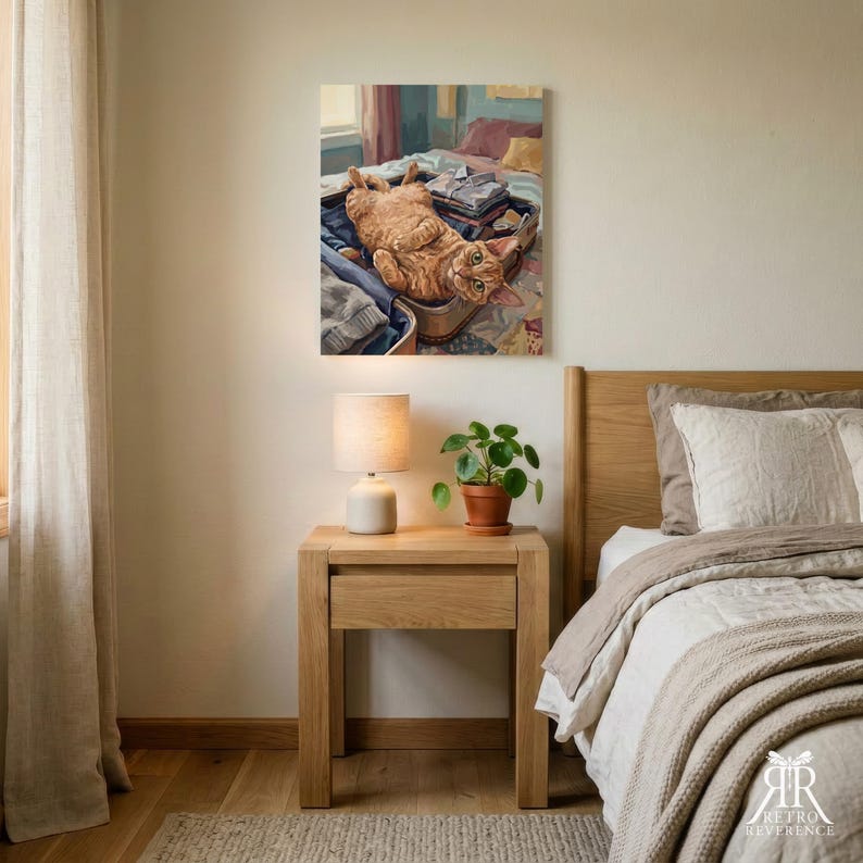 Puede incluir: Una impresi&oacute;n de arte mural rectangular que representa a un gato atigrado naranja acostado boca arriba dentro de una maleta abierta llena de ropa doblada. El gato tiene ojos verdes y est&aacute; colocado sobre una cama con una colcha estampada.