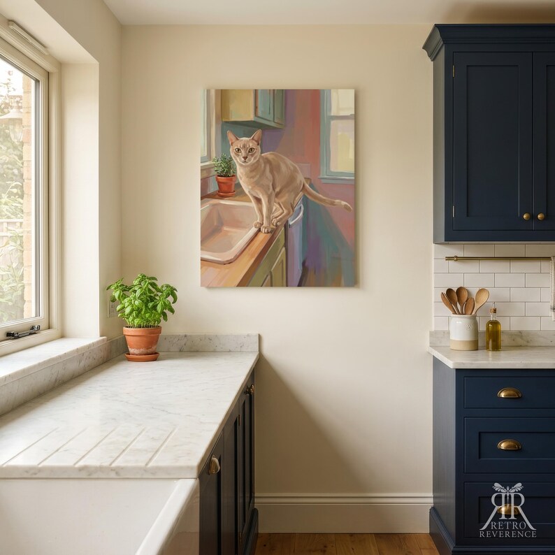 May include: A rectangular wall art print featuring a painting of a light tan cat standing on a kitchen sink counter. The artwork depicts a domestic scene with soft brushstrokes, warm lighting, and a cat looking directly forward in a kitchen.