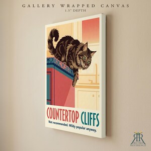 May include: A gallery wrapped canvas with a 1.5 inch depth featuring a brown tabby cat perched on a red kitchen counter. The text reads COUNTERTOP CLIFFS, Not recommended. Wildy popular anyway. The art style uses flat colors and bold lines.