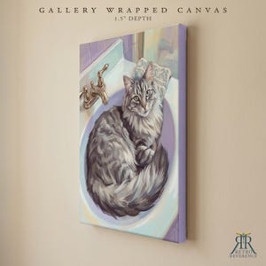 May include: A gallery wrapped canvas with a 1.5 inch depth featuring a painting of a fluffy grey tabby cat sitting inside a white bathroom sink with a gold faucet. The artwork displays the cat curled up in the basin with soft purple tones.
