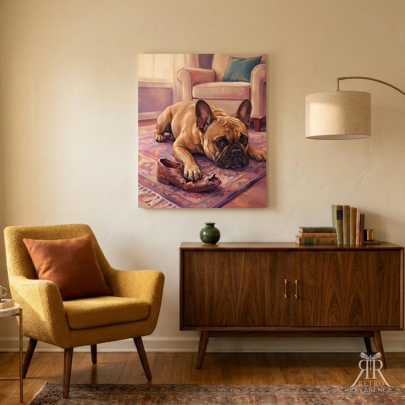 May include: A rectangular wall art print featuring a tan French Bulldog lying on a patterned rug with a brown leather shoe between its front paws. The dog has dark eyes and ears, and the background shows a room with a chair and soft lighting.
