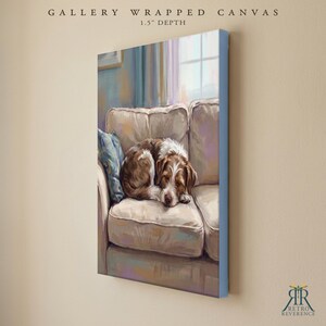 May include: A gallery wrapped canvas with a 1.5 inch depth featuring a painting of a brown and white dog curled up on a light-colored sofa. The artwork displays a soft, painterly style with a blue cushion visible on the left side of the couch.