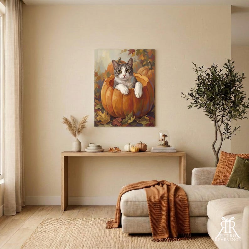 May include: A rectangular wall art print featuring a grey and white tabby cat sitting inside a large orange pumpkin. The scene is set against a background of autumn leaves and additional pumpkins, rendered in a warm, painterly style with soft lighting.