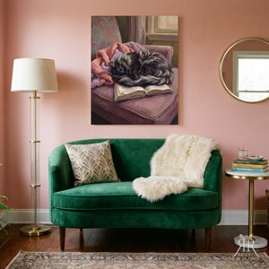 May include: A dark green velvet loveseat with a patterned throw pillow and a white faux fur throw blanket. Beside it stands a tall floor lamp with a white shade and a small round side table holding a stack of books and a glass.