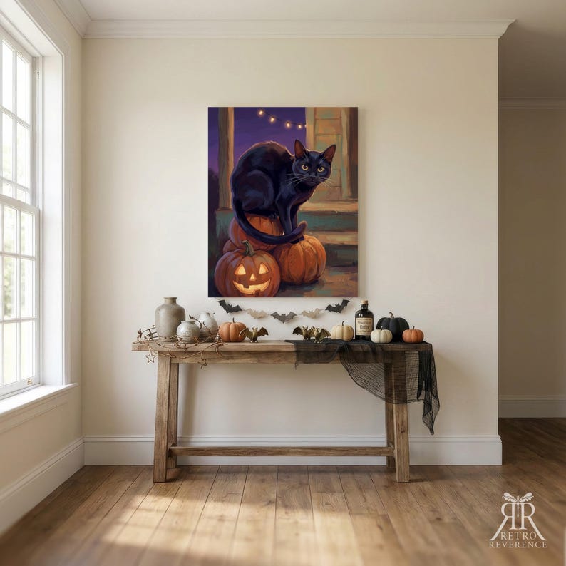 May include: A rectangular wall art print featuring a black cat sitting on a stack of orange pumpkins, including one carved jack-o'-lantern. The scene is set on a porch at dusk with string lights in the background and a purple sky.