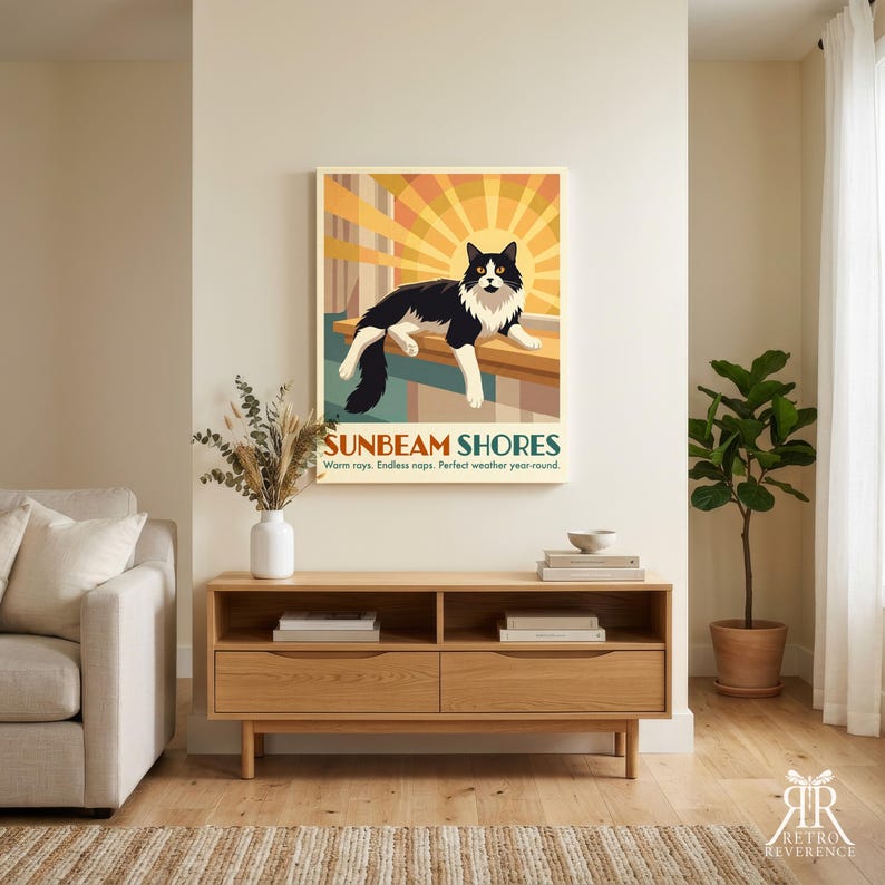 May include: A rectangular wall art print featuring a black and white cat lying on a ledge against a stylized yellow and orange sunburst background. The text reads SUNBEAM SHORES, Warm rays. Endless naps. Perfect weather year-round.