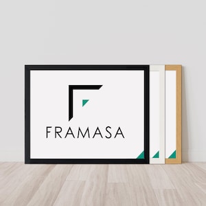 May include: Three framed art prints leaning against a white wall. The front frame is black, displaying the word "FRAMASA" and a logo with a black "L" shape and a teal triangle. The other frames are white and natural wood.