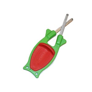 May include: A handheld knife sharpener featuring a bright green plastic frame with a red textured thumb grip in the center. Two crossed metal sharpening rods are positioned at the top of the tool, designed for honing blades with a manual motion.