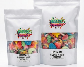 May include: Two white stand-up pouches of assorted gummy candies. The pouches have a clear window showing the colorful candies. The text "FREEZE MUNCH" is above the window. The text "ULTIMATE GUMMY MIX ASSORTED" is below the window.