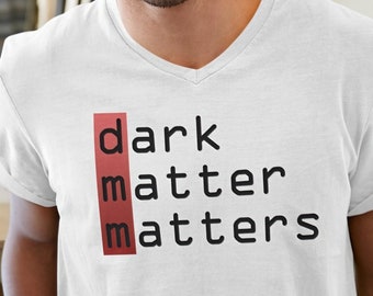 May include: White V-neck t-shirt with the text "dark matter matters" printed in black letters with a red background.