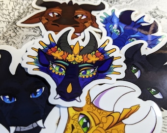 May include: A set of five colorful dragon head stickers. The stickers feature different dragon designs with various colors, including blue, black, yellow, and brown. The stickers are perfect for adding a touch of whimsy to laptops, water bottles, or journals.