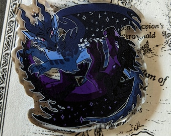 May include: A clear acrylic keychain featuring two stylized dragons. One dragon is dark blue with a starry wing, the other is black with purple accents. The dragons are intertwined, with a silver-colored clasp at the top.