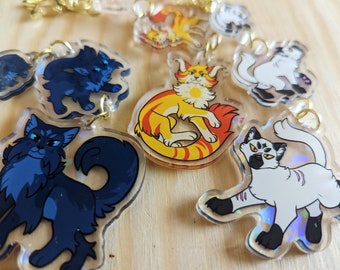 Puede incluir: Un conjunto de ocho llaveros de acrílico transparente con gatos de dibujos animados con diferentes colores de pelaje y poses. Los llaveros están diseñados con un efecto holográfico.