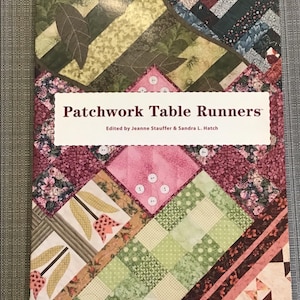 May include: Book cover featuring a patchwork quilt design with a title that reads "Patchwork Table Runners" and the text "Edited by Jeanne Stauffer & Sandra L. Hatch" and "HOUSE of WHITE BIRCHES".