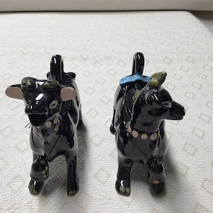 Gorgeous Ceramic Cows ~ so cute !!  Black with blue ribbons, pink & yellow collars and “cow bells” and gold ears