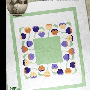 May include: A white quilted quilt with a pansy appliqué design. The quilt features a central green square, surrounded by a border of pansies in purple, yellow, and orange. The text "PANSY APPLIQUÉ & QUILTED QUILT" is displayed at the top.