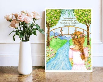 May include: A white vase filled with light pink roses next to a rectangular print featuring a watercolor illustration of a person with a braided hairstyle and flower crown standing before a stream, bridge, and trees with the text: It's not what the world holds for you. It's what you bring to it. - Anne of Green Gables.