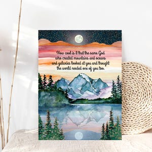 May include: A watercolour print depicting a mountain scene with a lake, trees, and a full moon. The sky blends from orange to blue, with the text: "How cool is it that the same God who created mountains and oceans and galaxies looked at you and thought the world needed one of you too."