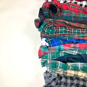 Stack of plaid and tartan blankets or fabric swatches available by Kawartha Sign & Pillow Co.