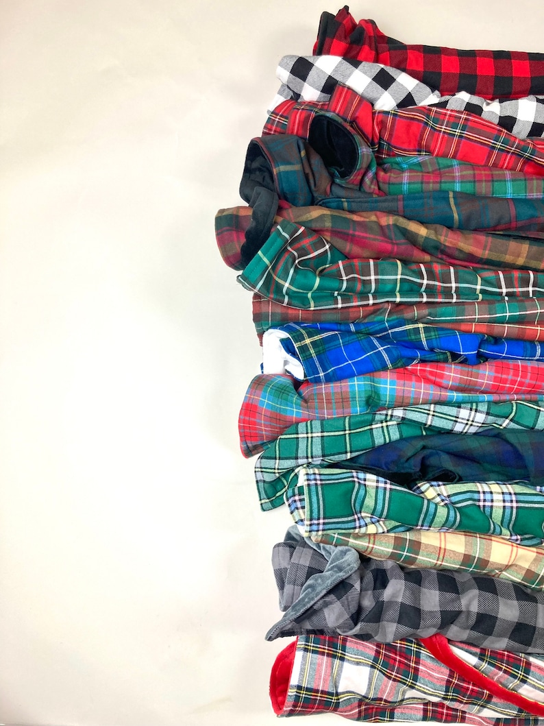 Stack of plaid and tartan blankets or fabric swatches available by Kawartha Sign & Pillow Co.