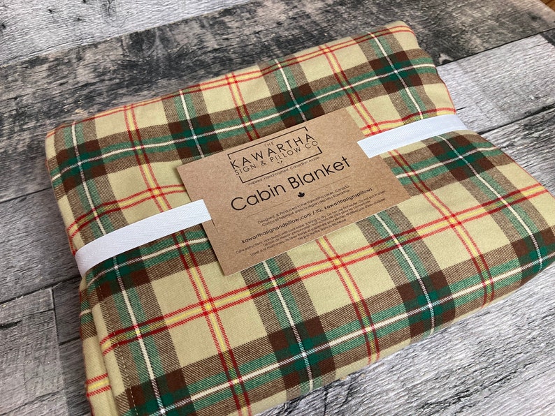 Saskatchewan tartan colour in plaid on cabin throw blanket, Cabin blanket tag on folded blanket