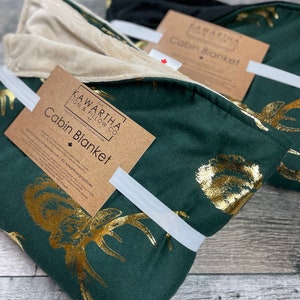Close up of Majestic Stag Cabin Blanket, gold deer hunter green with gold foil deer print, available with tan and black backing option
