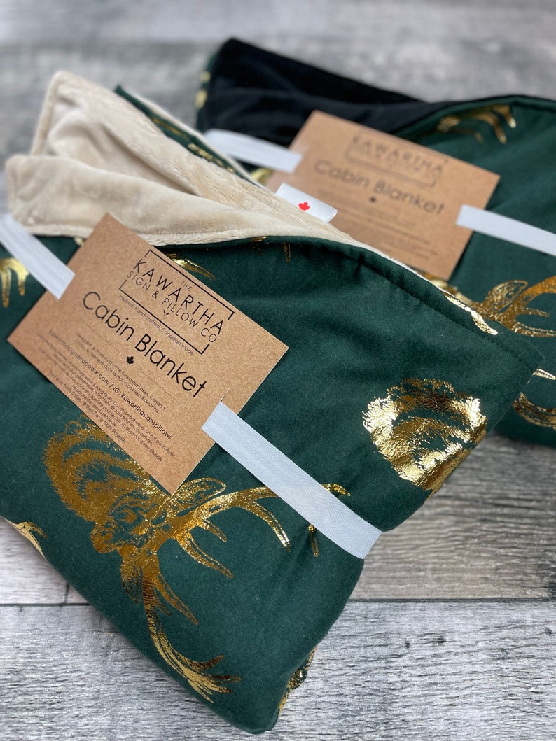 Close up of Majestic Stag Cabin Blanket, gold deer hunter green with gold foil deer print, available with tan and black backing option